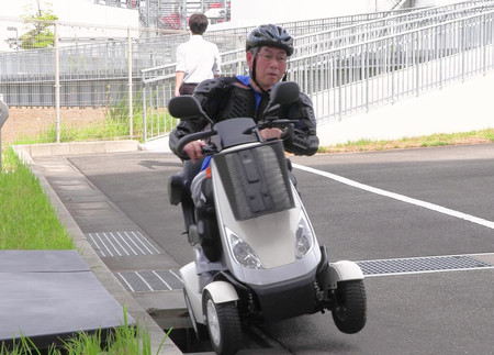 側溝で脱輪する電動車いすの再現実験（ＮＩＴＥ提供）