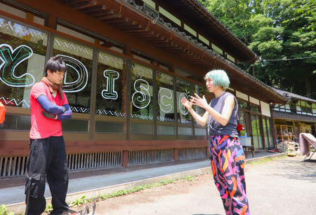 古民家を改修したゲストハウスの前で話す田村早苗さん（右）＝６月２０日、石川県能登町