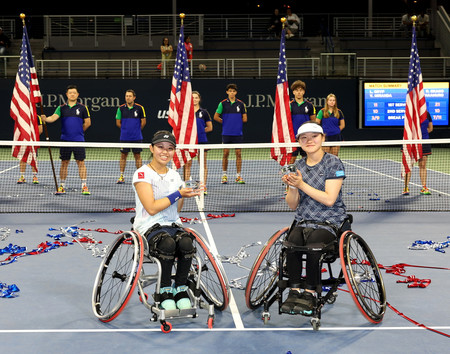 全米オープン車いすテニスのジュニア部門女子ダブルスで優勝し、トロフィーを手にする高室侑舞（手前右）と岡野莉央＝６日、ニューヨーク