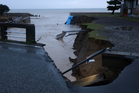 大雨の影響で川が増水し、崩れた斜面＝２１日午後、石川県珠洲市