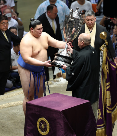 日本相撲協会の八角理事長（右）から賜杯を受け取る大の里＝２２日、東京・両国国技館