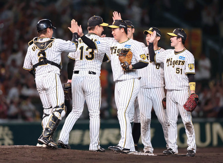 巨人に勝ち、喜ぶ阪神ナイン。右端は決勝打を放った中野＝２２日、甲子園