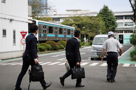 ＪＲ東日本東京総合車両センターに立ち入り検査に入る国土交通省の職員ら＝２４日午前、東京都品川区