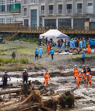 大雨で氾濫した塚田川の河口付近で、安否不明者の捜索を続ける消防隊員ら＝２８日午前、石川県輪島市