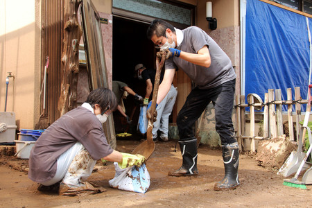 大雨で自宅に入った泥を片付ける住民ら＝２８日午前、石川県輪島市