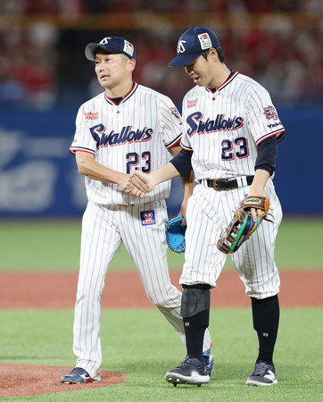 ３番手として登板した石川（左）と握手するヤクルトの青木＝２日、神宮