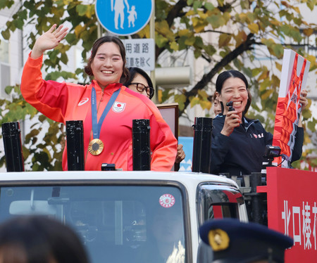 凱旋（がいせん）パレードで手を振る北口榛花選手（左）＝１３日午前、北海道旭川市