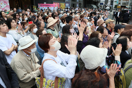 衆院選が公示され、街頭演説会で候補者らの訴えに耳を傾ける聴衆＝１５日午前、東京都豊島区