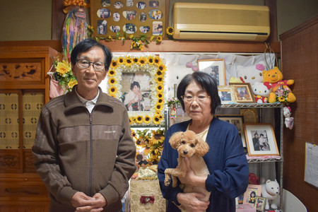 猪野詩織さんの父憲一さん（左）と母京子さん。自宅には詩織さんの写真と共に、好きだったヒマワリやキャラクターグッズなどが飾られている＝２１日、埼玉県上尾市