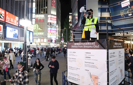 歌舞伎町で路上飲酒規制について呼び掛ける男性=31日午後、東京都新宿区