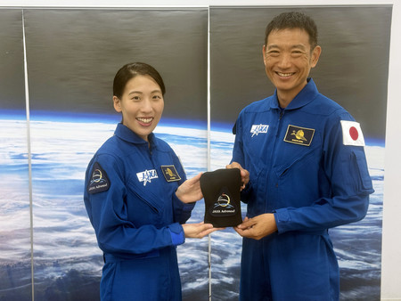 新たに宇宙飛行士に認定された米田あゆさん（左）と諏訪理さん。手にしているのは、２人がデザインのアイデアを出して制作したワッペン。月を跳ねるウサギと地球、その先に赤い火星が描かれている＝１０月２４日、東京都千代田区