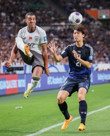 Ｗ杯アジア最終予選の中国戦でプレーする高井（右）＝９月５日、埼玉スタジアム