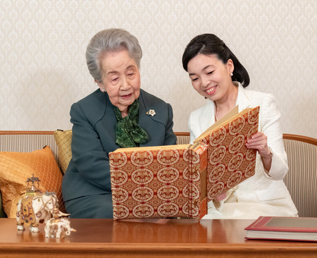 孫の彬子さまとご家族のアルバムを眺められる三笠宮妃百合子さま＝２０２２年５月１９日、東京都港区の三笠宮邸（宮内庁提供）