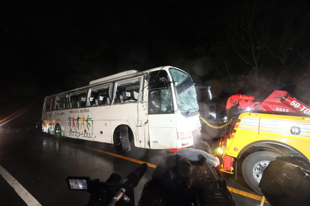 横転事故を起こし、現場から運び出される観光バス＝２０２２年１０月、静岡県小山町