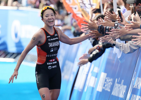 笑顔でゴールに向かう、女子で優勝した高橋侑子＝１７日、東京・お台場海浜公園