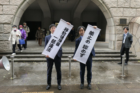 厚木基地の第５次騒音訴訟で、判決内容が書かれた紙を掲げる原告側弁護士ら＝２０日午後、横浜市中区