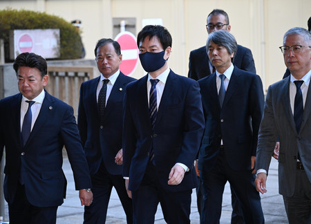 東京地裁に入る前衆院議員の秋本真利被告（左から３人目）ら＝２５日午前、東京都千代田区（代表撮影）