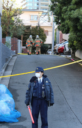 火災があった猪口邦子参院議員宅に向かう消防隊員（奥）と警戒する警察官＝２８日午前、東京都文京区