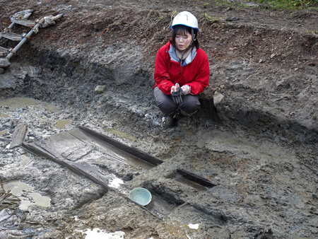 女布遺跡で出土した鎌倉時代の木棺墓と青磁のおわん＝２９日、京都府舞鶴市