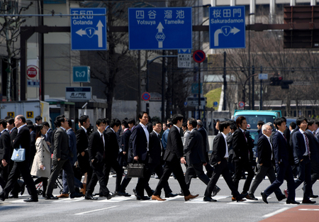 横断歩道を渡るスーツ姿の会社員ら（ＡＦＰ時事）