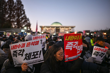 ６日、ソウルの韓国国会の外で尹錫悦大統領の退陣を求めるデモ隊（ＡＦＰ時事）