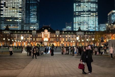 東京駅をバックに写真を撮る人たち＝１６日、東京都千代田区（ＡＦＰ時事）