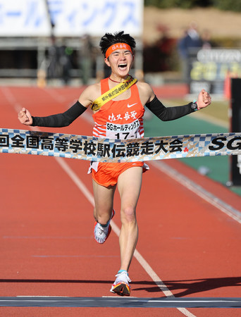 男子の１位でゴールする佐久長聖アンカーの石川浩輝＝２２日、たけびしスタジアム京都