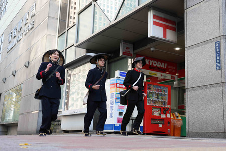 創業時などの制服姿で年賀状配達に出発する郵便局員ら=1日午前、東京都新宿区