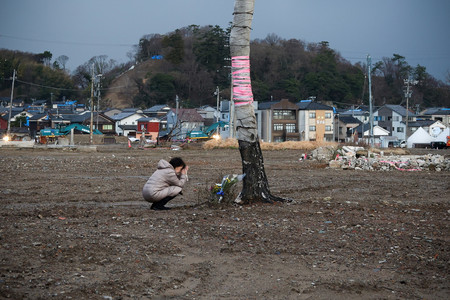 観光名所「朝市通り」付近で手を合わせる人＝１日午後、石川県輪島市