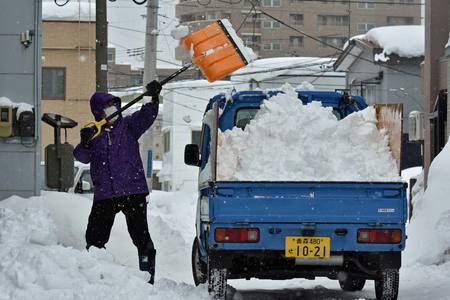 除雪作業に精を出す男性。トラックに積み込んだ雪は岸壁まで捨てに行くという＝９日、青森市