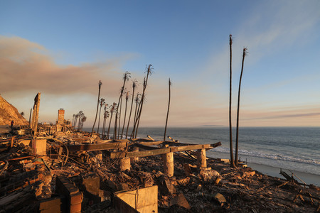 １０日、米西部カリフォルニア州マリブで、山火事により焼失した海岸沿いの民家（ＡＦＰ時事）