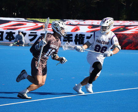 ラクロス全日本クラブ選手権の男子決勝でプレーするグリズリーズ（左）とファルコンズの選手＝２０２３年１２月３日、東京・大井ホッケー競技場