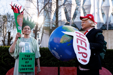 ロンドンの在英米大使館前で、トランプ大統領の環境政策に抗議する市民団体のメンバー＝１１日（ＥＰＡ時事）