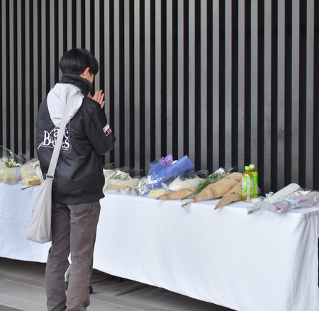 ＪＲ長野駅前で発生した殺傷事件で、現場に設置された献花台の前で手を合わせる男性＝２３日午後、長野市