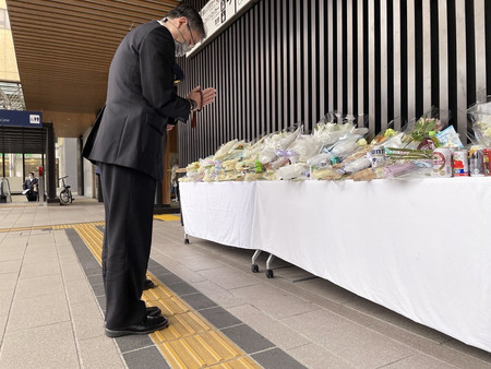 JR長野駅前で発生した殺傷事件を受け、事件現場に設置された献花台で手を合わせる長野県警の鈴木達也本部長=24日午前、長野市