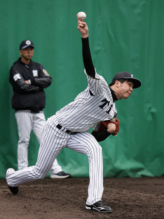 ブルペンで投球練習する阪神の才木(右)。左は藤川監督=6日、沖縄県宜野座村