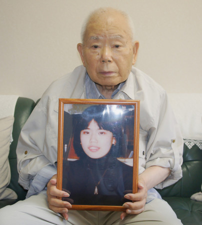 有本恵子さんの写真を抱える父明弘さん＝２０２２年８月２日、神戸市
