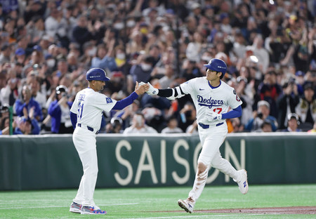 3回、2ランを放ち、三塁コーチ(左)とタッチするドジャースの大谷=15日、東京ドーム
