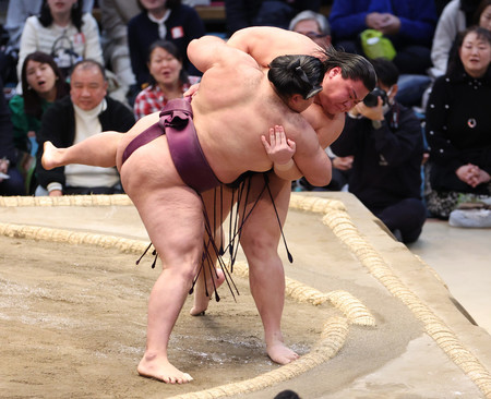 草野(右)は下手投げで狼雅を破って十両優勝を決める=20日、エディオンアリーナ大阪