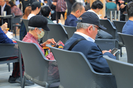 大阪・関西万博会場内でスマートフォンを操作する来場者=18日、大阪市此花区