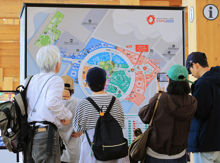 大阪・関西万博会場に設置された地図を見る人たち=18日、大阪市此花区