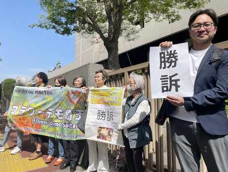 上田清司参院議員の元公設第１秘書による性暴力を巡る訴訟の判決後、「勝訴」と書かれた紙を手に喜ぶ支援者ら＝２４日、東京・霞が関