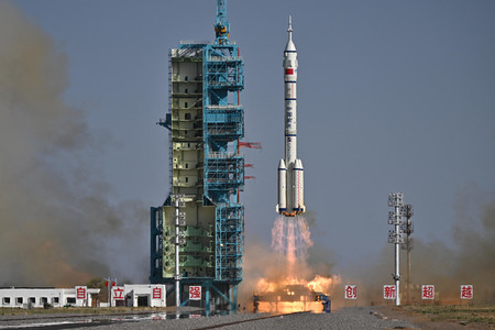24日、中国北西部の酒泉衛星発射センターから打ち上げられる「神舟20号」を搭載したロケット(AFP時事)