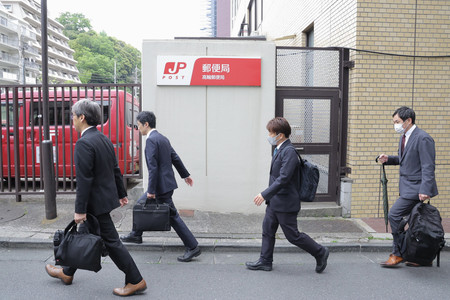立ち入り検査のため高輪郵便局に入る関東運輸局の職員ら＝２５日午前、東京都港区