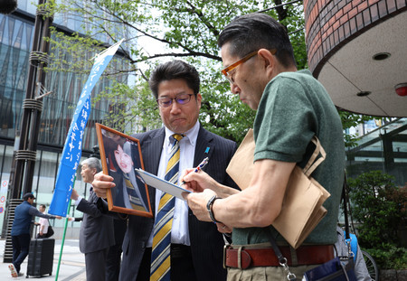 北朝鮮による拉致被害者の救出を求める署名活動を行う家族会代表の横田拓也さん(左)=26日午前、東京都中央区