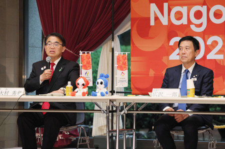 アジア・アジアパラ大会の組織委員会の理事会であいさつする大村秀章会長(左)。右は広沢一郎会長代行=28日、名古屋市内