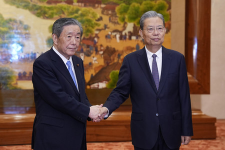 中国の趙楽際・全国人民代表大会常務委員長(右)と握手する日中友好議員連盟会長の森山裕自民党幹事長=29日、北京の人民大会堂(代表撮影・時事)