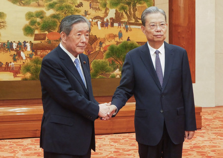 中国共産党序列3位の趙楽際・全国人民代表大会常務委員長(右)と握手する日中友好議員連盟会長の森山裕自民党幹事長=29日、北京市