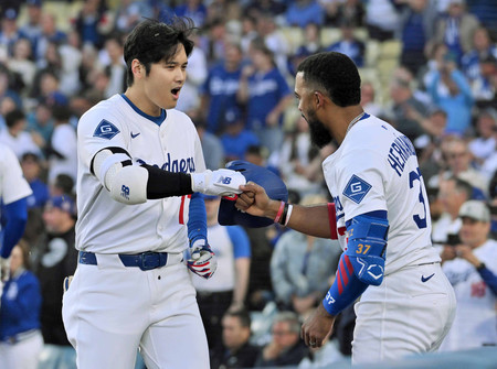 マーリンズ戦の1回、ソロ本塁打を放ち祝福されるドジャースの大谷(左)=29日、ロサンゼルス