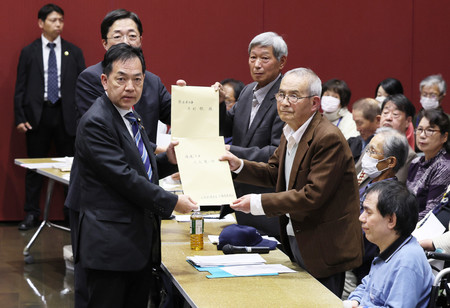 水俣病の被害者団体との懇談会で、要望書を受け取る浅尾慶一郎環境相(左手前)=30日午後、熊本県水俣市